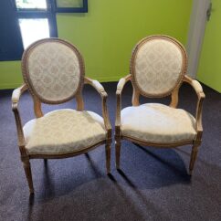 Paire de fauteuils de style Louis XVI en noyer massif rechampi et tapissé, chevillés