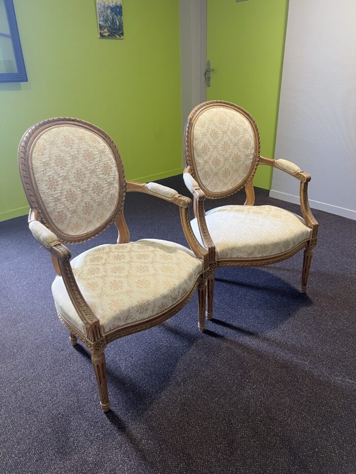 Paire de fauteuils de style Louis XVI en noyer massif rechampi et tapissé, chevillés