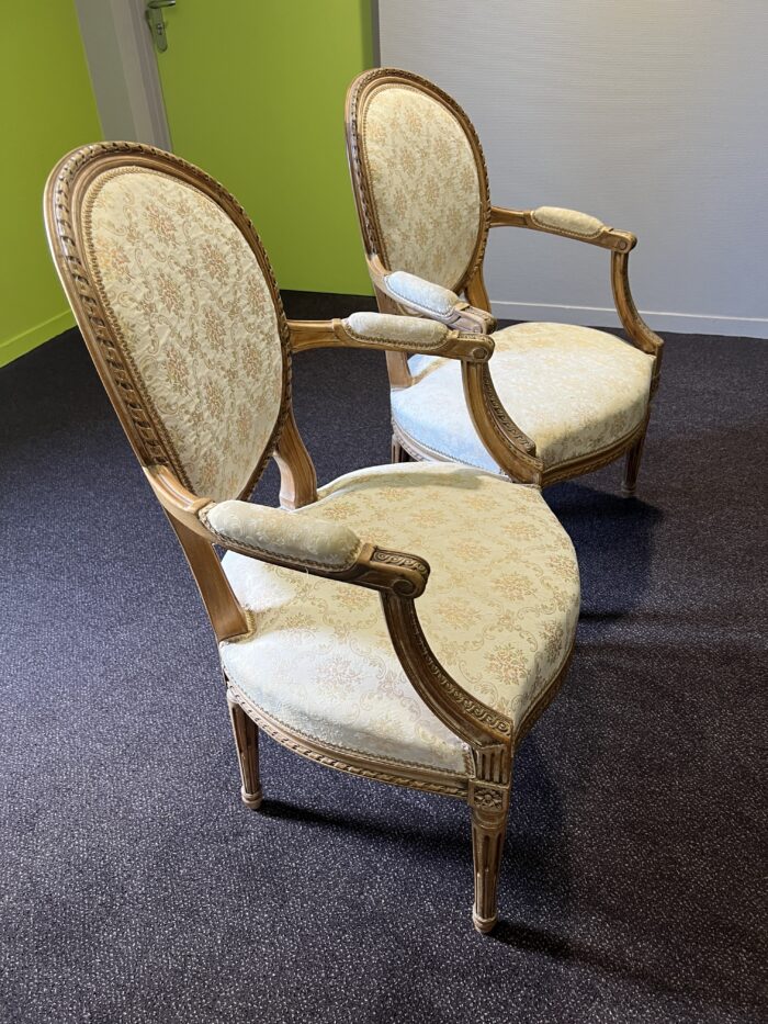 Paire de fauteuils de style Louis XVI en noyer massif rechampi et tapissé, chevillés
