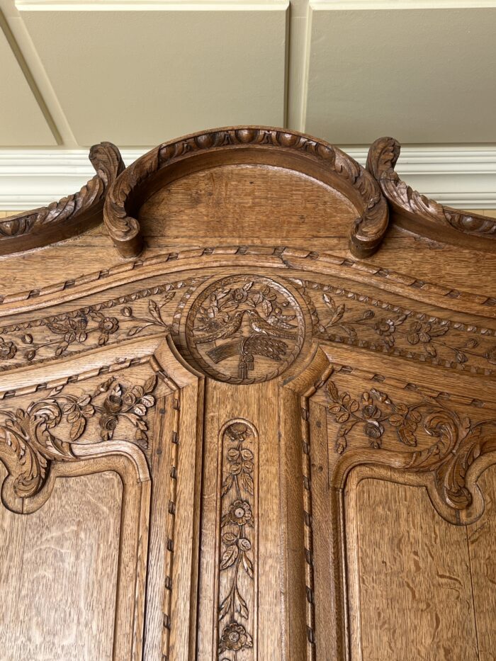 Très belle et ancienne armoire Normande du XIXe siècle, en chêne clair richement sculpté