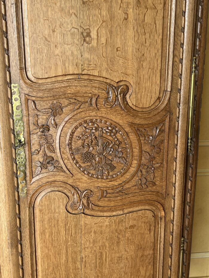 Très belle et ancienne armoire Normande du XIXe siècle, en chêne clair richement sculpté
