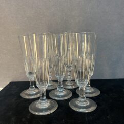 Série de sept flûtes à champagne en cristal taillé, héritées de l’époque Napoléon III.