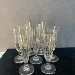 Série de sept flûtes à champagne en cristal taillé, héritées de l’époque Napoléon III.