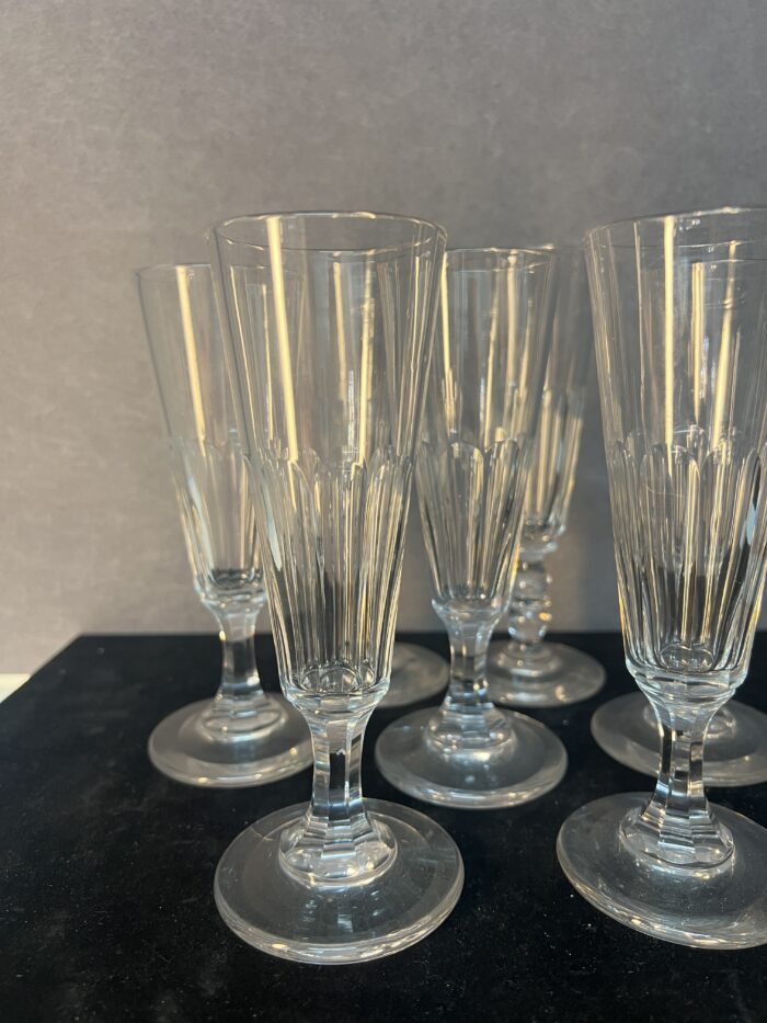 Série de sept flûtes à champagne en cristal taillé, héritées de l’époque Napoléon III.