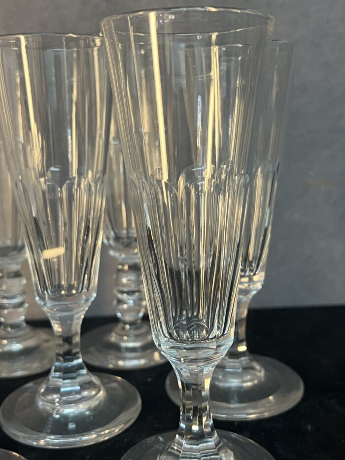 Série de sept flûtes à champagne en cristal taillé, héritées de l’époque Napoléon III.