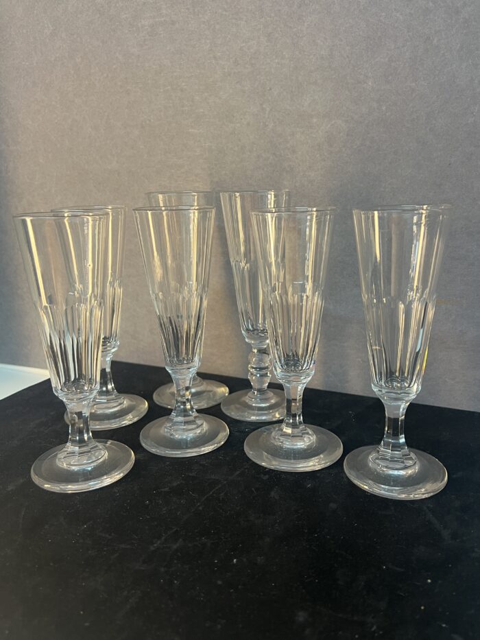 Série de sept flûtes à champagne en cristal taillé, héritées de l’époque Napoléon III.