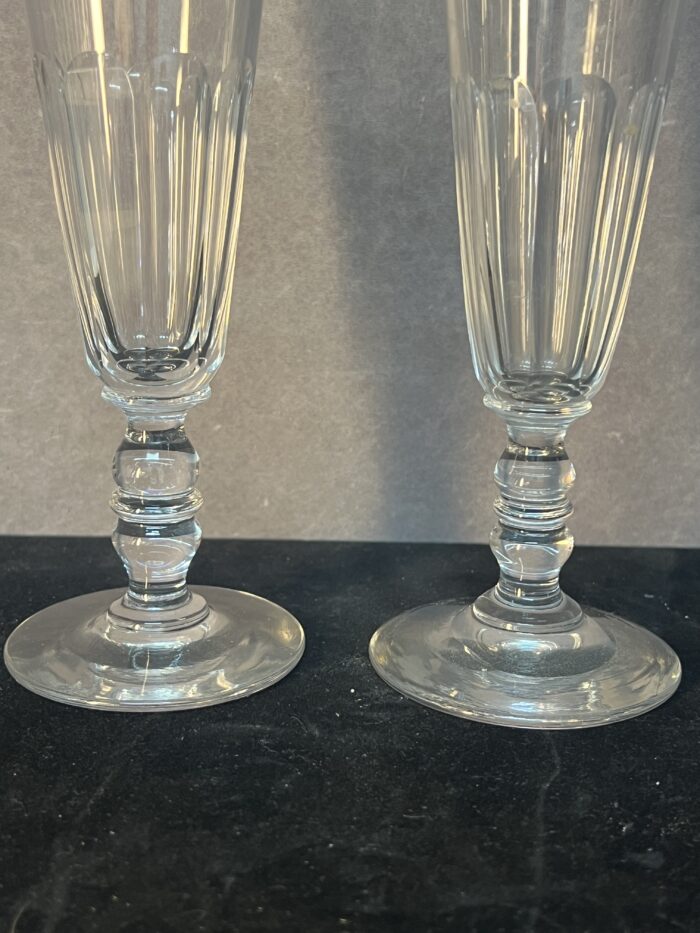 Série de sept flûtes à champagne en cristal taillé, héritées de l’époque Napoléon III.